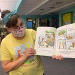 Colorful children's book being read by a woman in a library, promoting literacy and early childhood education.